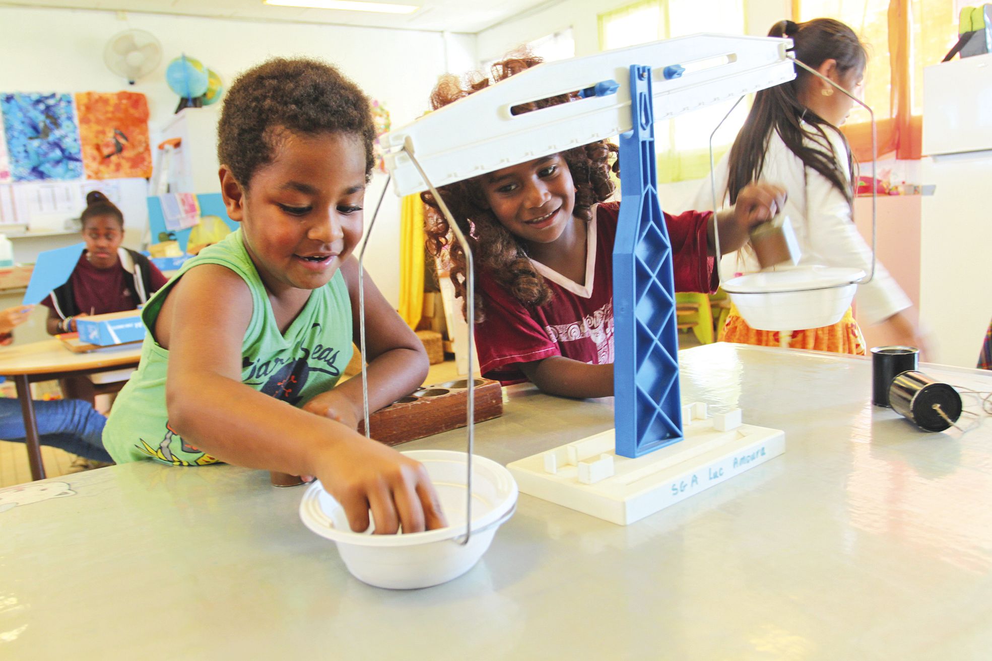 Païta, jeudi 23 juin. Cette semaine, c'est une balance « dénichée dans le fond d'un cagibi » que les enfants ont trouvée dans la salle de découverte. Avec un jeu de poids incomplet, les enfants s'amusent à faire monter et descendre les plateaux.