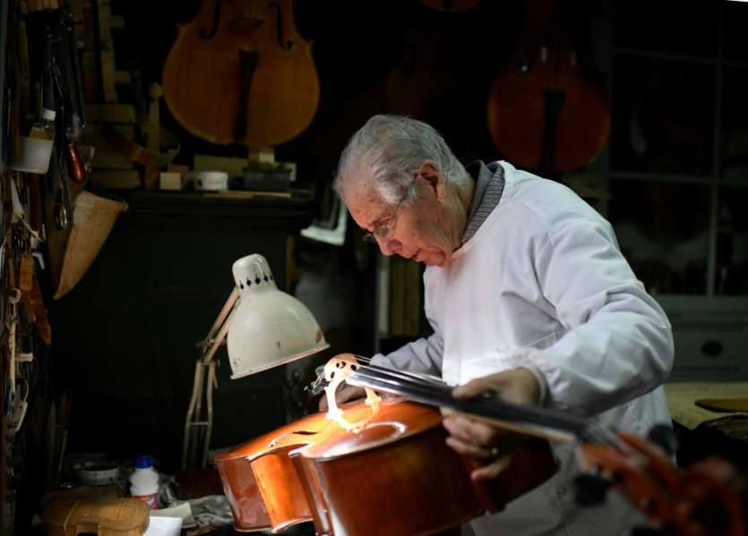 Un Violon Est Sur Un Support Devant Un Mur Qui Dit  Le Violon .